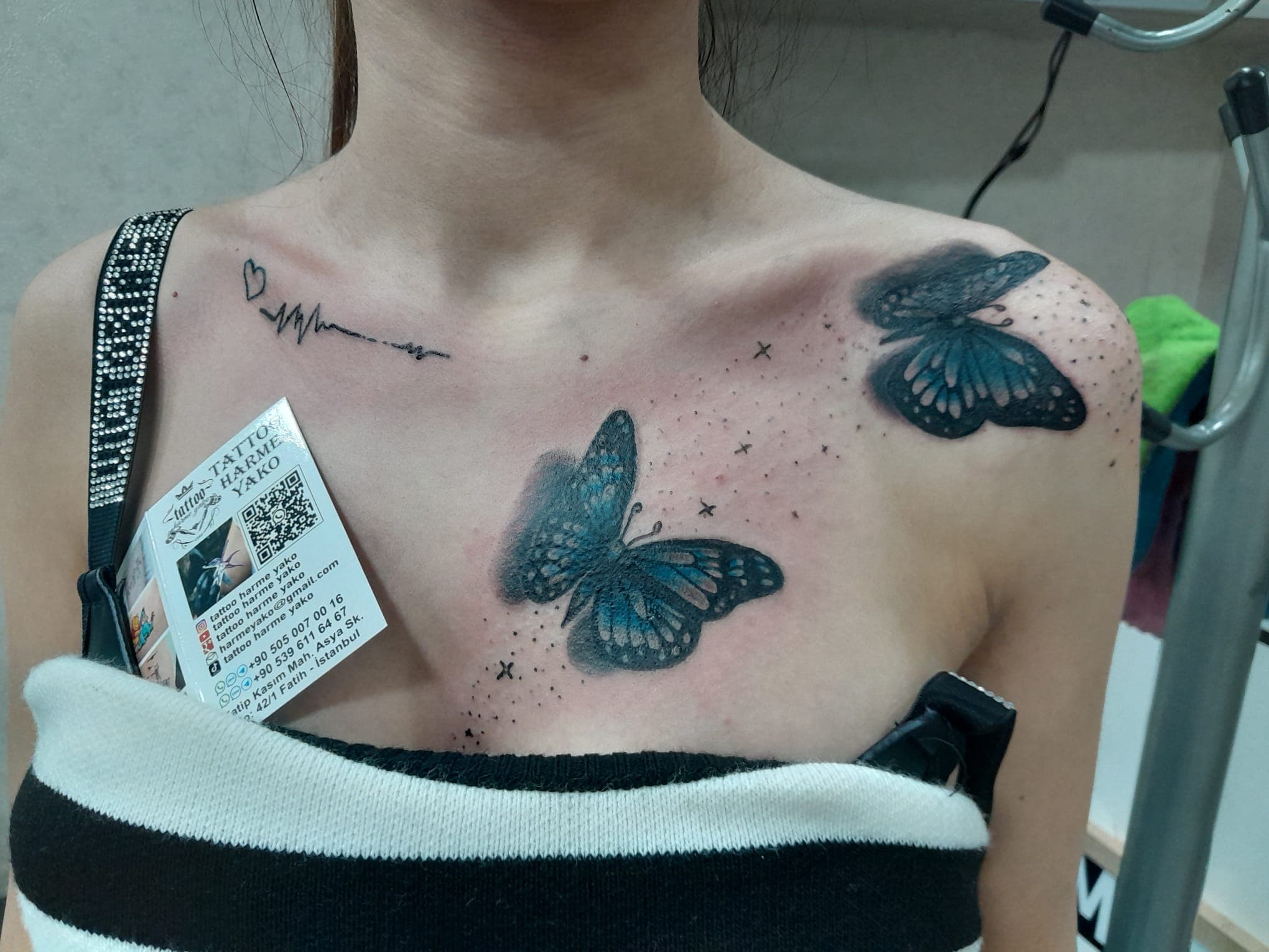 Göğüs üzerine uygulanmış 3D kelebek dövme çalışması — Tattoo Harme Yako kartviziti ile